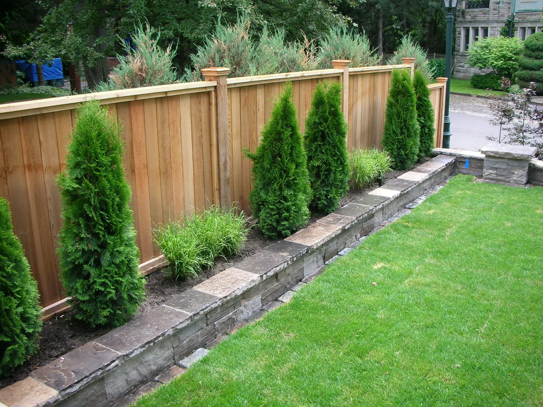 Wood privacy fence with flower bed in front